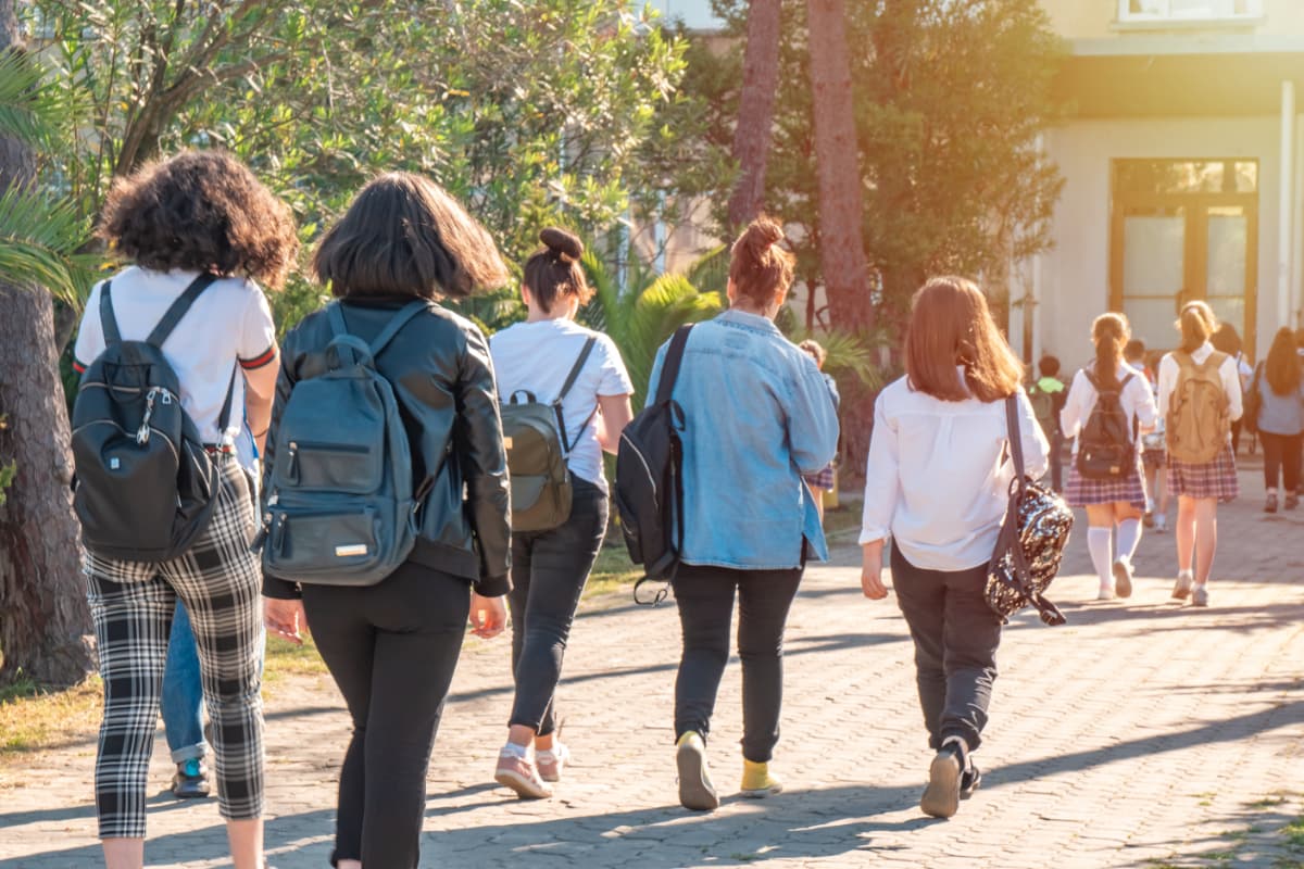 groups of kids walking towards a school building